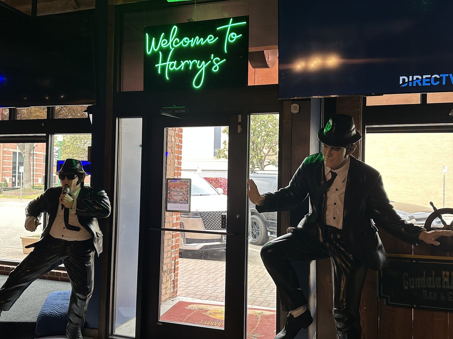The front door at GuadalaHARRY's, under the Welcome to Harry's neon, flanked by the Blues Brothers