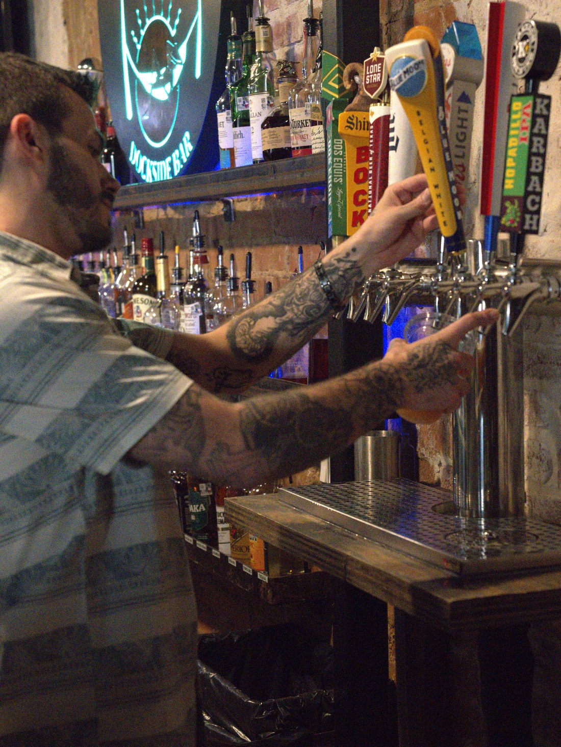 A bartender pouring a draft behind the bar at GuadalaHARRY's